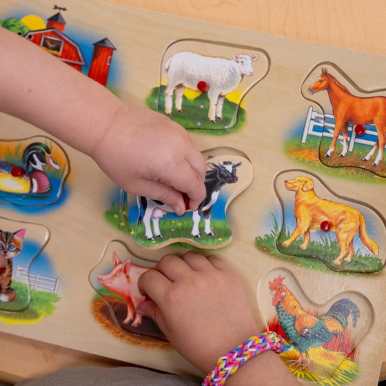 A child's hands completing an animal puzzle