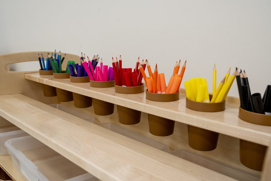 Colored pencils sorted by color in wooden cups